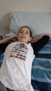 Jonah in daddy's "big blue bed," sporting the "You Can Never Have Too Many Trains" t-shit his "aunt KP" for him for Christmas. 